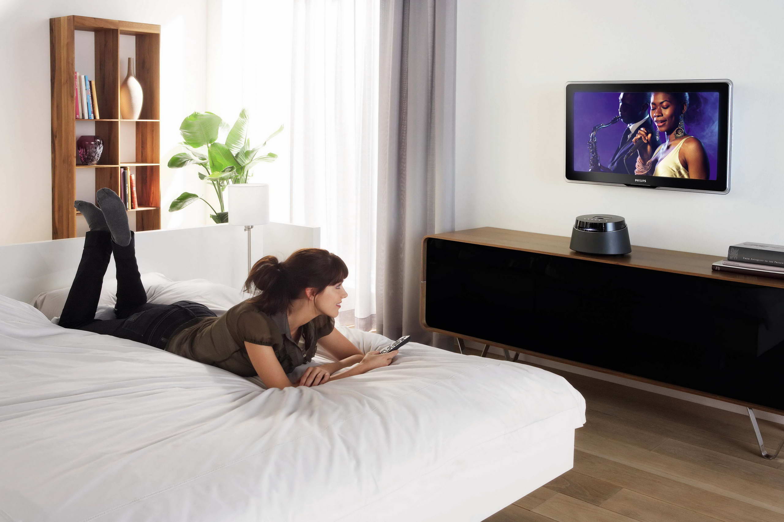 В спальне перед телевизором. Телевизор в спальне. Телевизор перед кроватью. Лежит перед телевизором. Люди в спальне.